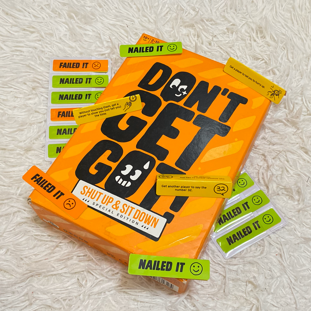 The box of Don't Get Got! along with mission cards sprawled on a white carpet.