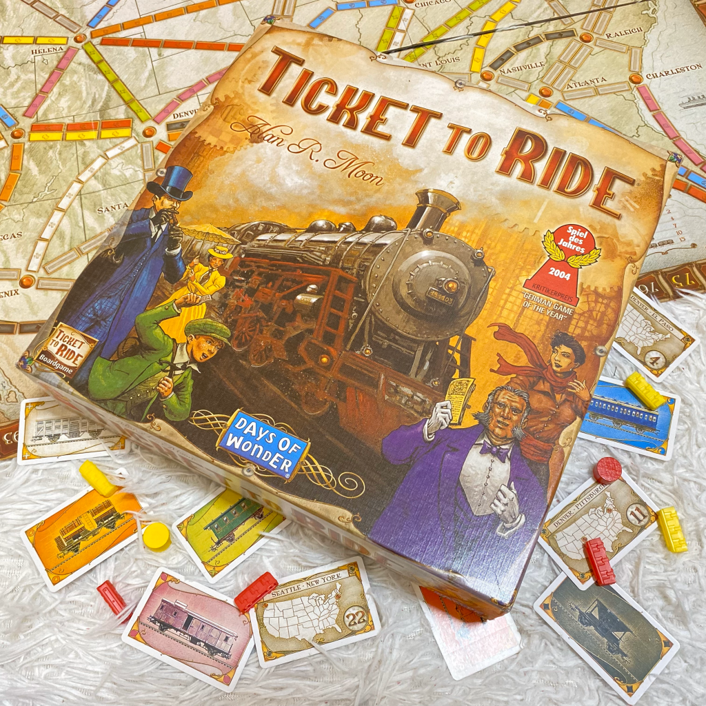 Ticket to Ride board game and components spread out on a white carpet